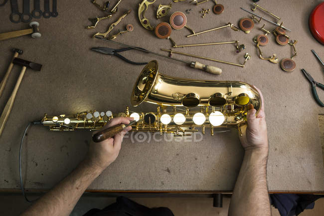 Ausgeschnittenes Bild des Instrumentenbauers beim Demontieren des Saxophons während der Reparatur — Stockfoto