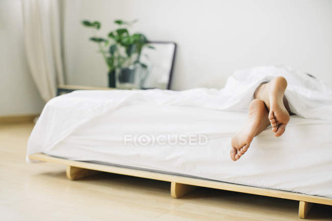 Ноги женщины лежат в постели — стоковое фото