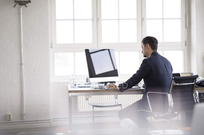 Businessman sitting in office, working on computer — Stock Photo