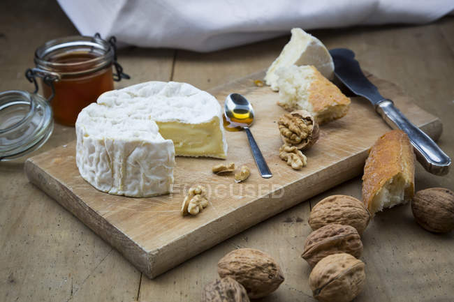 Camembert avec pain, noix et miel sur bois — Photo de stock