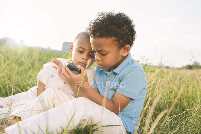 Щасливі афро-американських хлопчиків в мобільний телефон, спрямований на вивчення поля — стокове фото