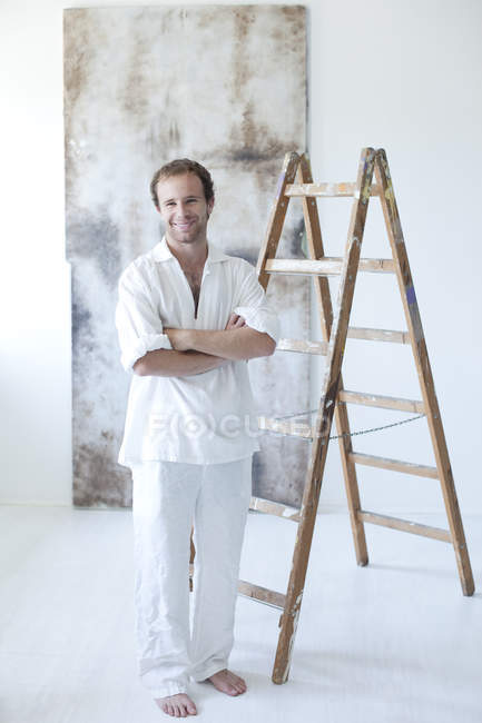 Portrait de jeune peintre souriant dans son atelier — Photo de stock