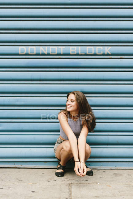 Brunette young woman in front of shutter — Stock Photo