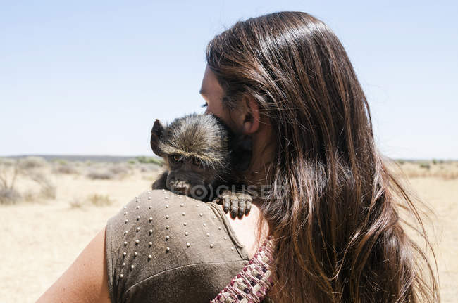 Namibia, primer plano de la mujer que sostiene el babuino bebé - foto de stock
