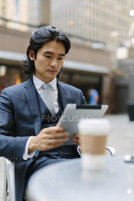 Geschäftsmann im Outdoor-Café schaut auf digitales Tablet — Stockfoto