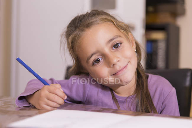 Ritratto di bambina sorridente con matita blu — Foto stock