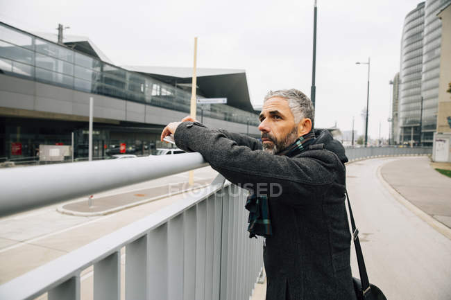 Austria, Vienna, uomo appoggiato su una ringhiera vicino alla stazione centrale — Foto stock