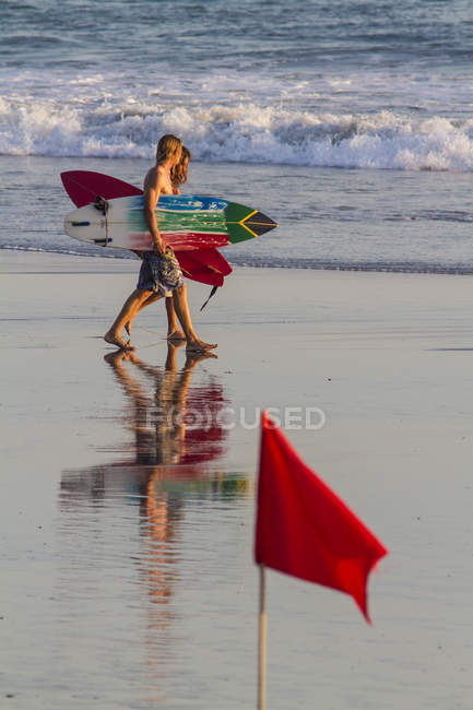 Indonesia, Bali, two surfers walking along the beach with their boards — Stock Photo