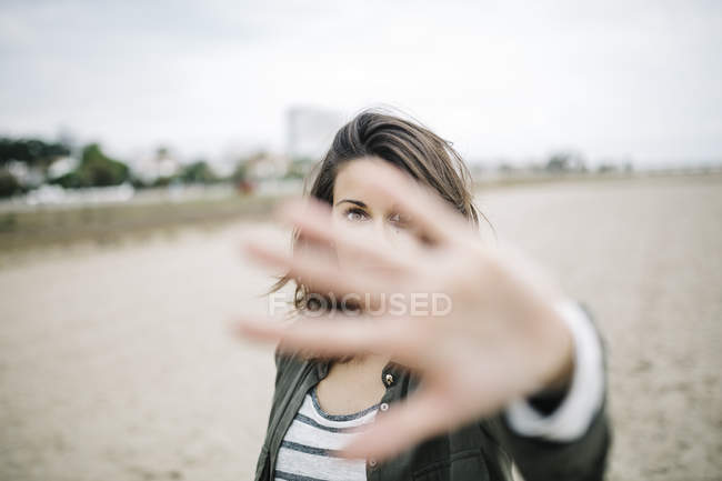 Young woman looking through her outstretched hand — Stock Photo