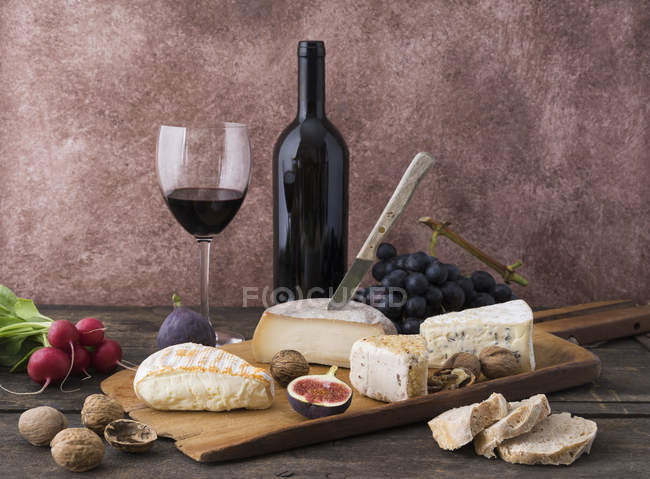 Piatto di formaggio con camembert, formaggio di noci, gorgonzola, taleggio e vino rosso — Foto stock
