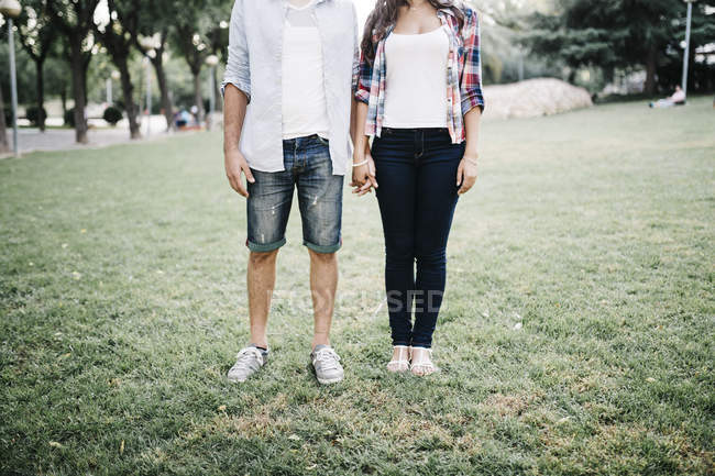 Couple amoureux debout sur la prairie dans le parc — Photo de stock