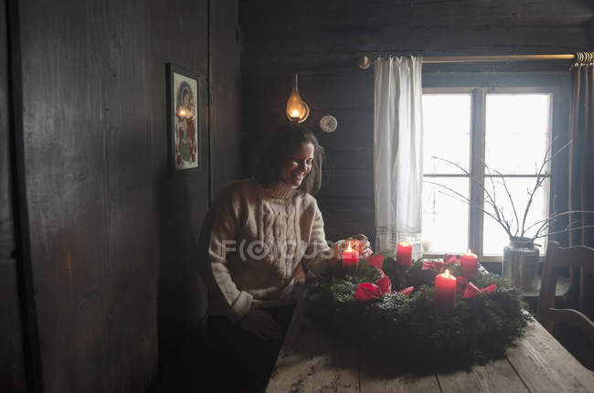 Smiling woman with Advent wreath in rustic room — Stock Photo