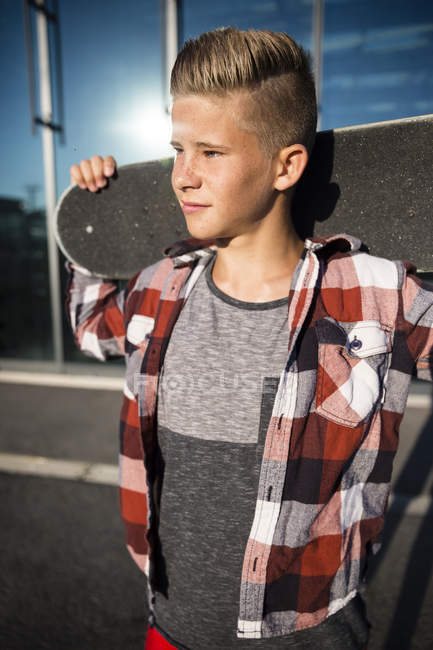 Fiducioso caucasico adolescente ragazzo in possesso di skateboard — Foto stock