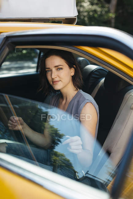 США, Нью-Йорк, портрет усміхнений молодої жінки отримують жовті таксі — стокове фото