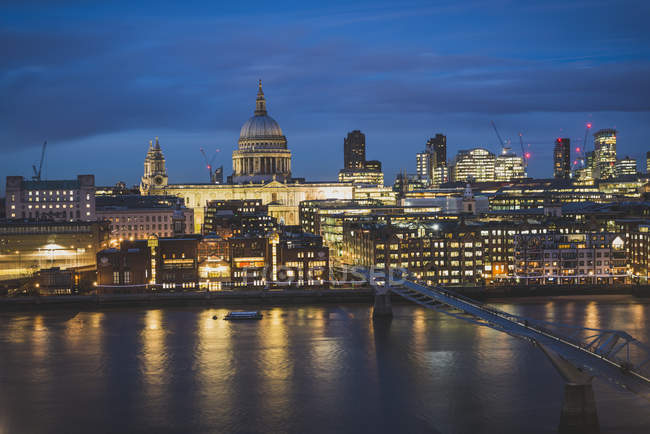 Royaume-Uni, Angleterre, Londres, St Paul's Cathedral und Millennium Bridge illuminé la nuit réfléchissant dans la rivière — Photo de stock