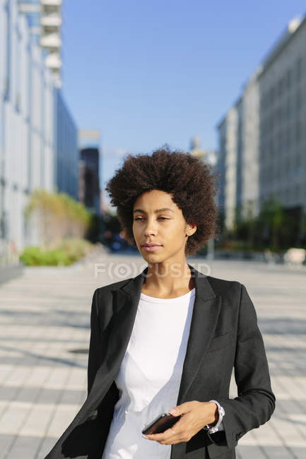 Retrato de mujer de negocios con smartphone al aire libre - foto de stock