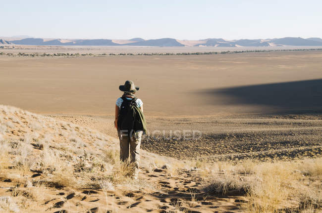 Намібія, Наміб, Sossusvlei, жінка з капелюх і рюкзак, дивлячись на горизонті — стокове фото