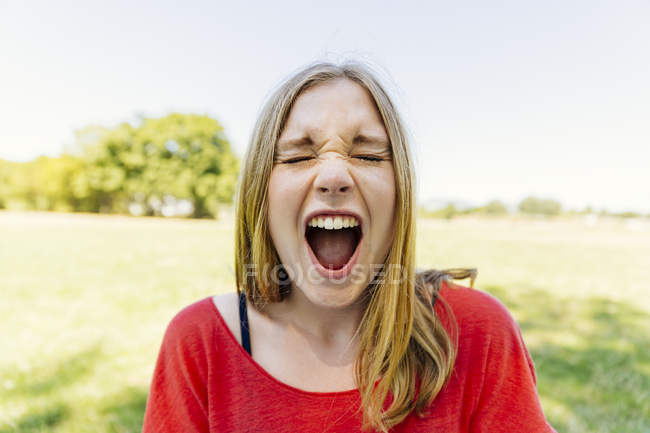 Portrait of teenage girl outdoors screaming — Stock Photo