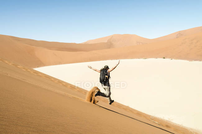 Namibia, Namib Desert, donna che corre lungo una duna sulla strada per Deadvlei — Foto stock