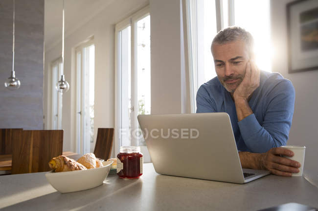 Älterer Mann arbeitet von zu Hause aus mit Laptop — Stockfoto
