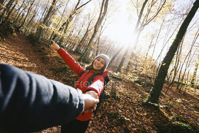 Donna sorridente nel bosco che tiene la mano dell'uomo — Foto stock