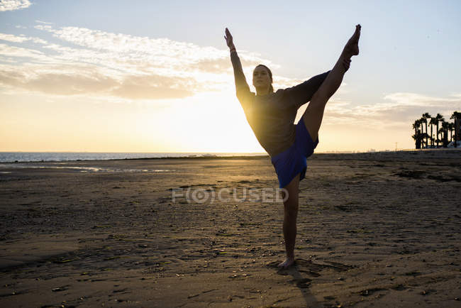 Spanien, puerto real, Silhouette einer jungen Frau beim Yoga am Strand bei Sonnenuntergang — Stockfoto