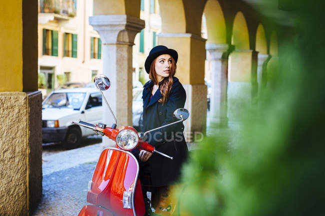 Italia, Verona, mujer joven con scooter - foto de stock