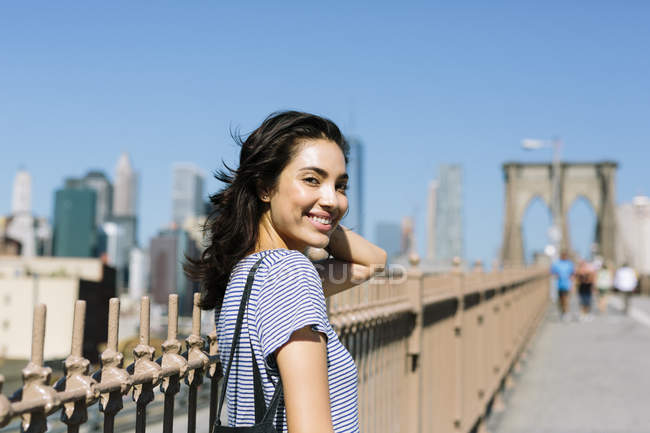 USA, New York City, portrait d'une jeune femme souriante sur Brooklyn Bridge — Photo de stock