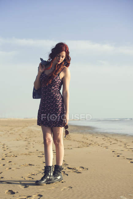 Portrait of redheaded young woman standing on the beach — Stock Photo