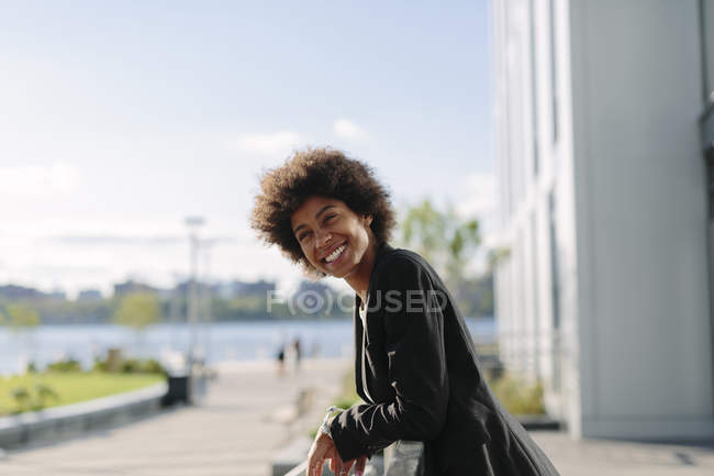 Portrait of smiling businesswoman leaning on railing — Stock Photo