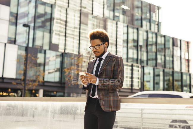 Jungunternehmer schaut im Freien aufs Handy — Stockfoto