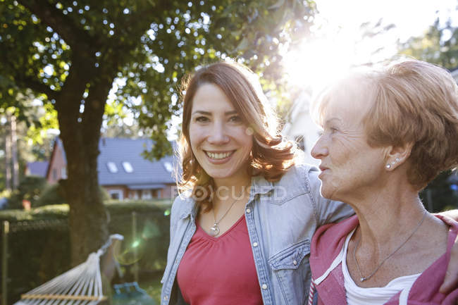 Ritratto di figlia adulta sorridente con madre anziana in giardino — Foto stock