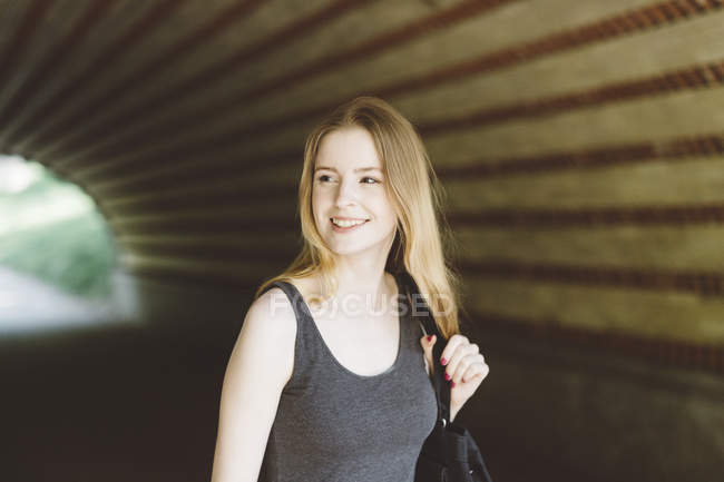 Giovane donna che cammina in un tunnel — Foto stock