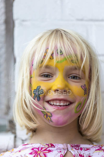 Fille avec peint visage souriant à la caméra — Photo de stock