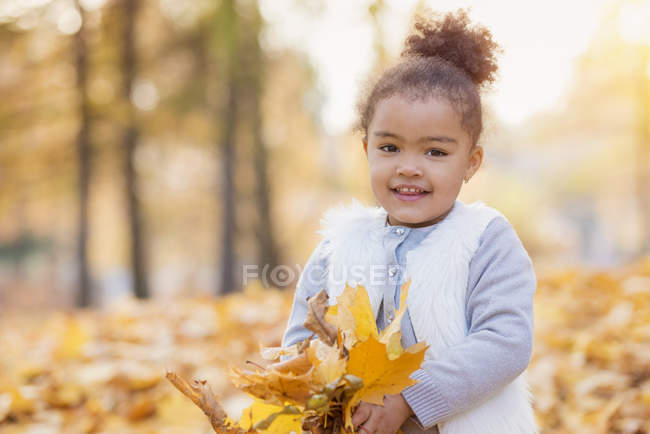 Little girl playing in autumn park — Stock Photo