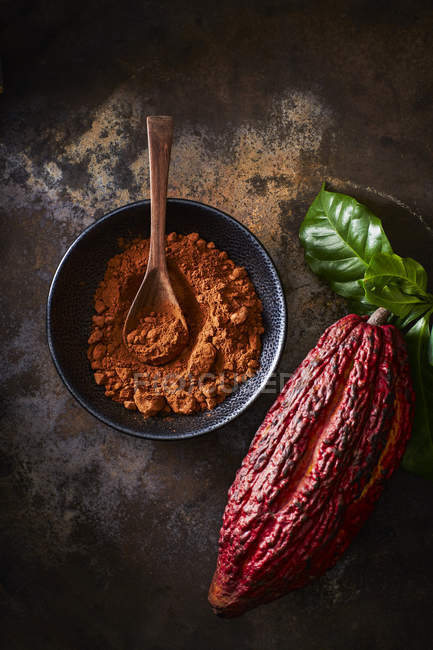 Cialda di cacao e ciotola di cacao su terreno arrugginito — Foto stock