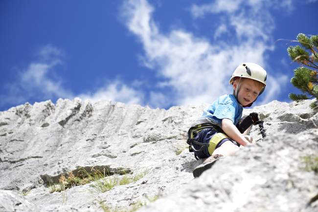 Menino pequeno escalando a rocha — Fotografia de Stock