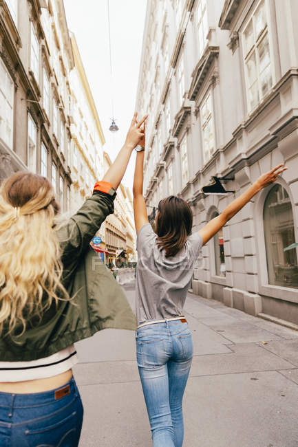 Austria, Vienna, rear view of two female friends exploring the old town — Stock Photo