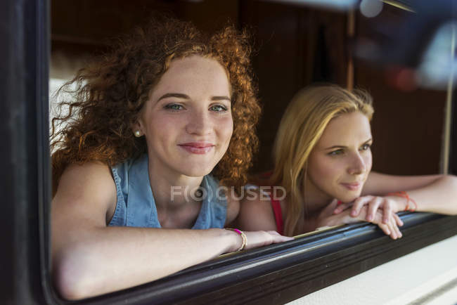 Duas amigas olhando pela janela da caravana — Fotografia de Stock