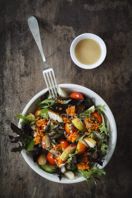 Fresh mixed salad with kohlrabi, tomato and cucumber on wood — Stock Photo