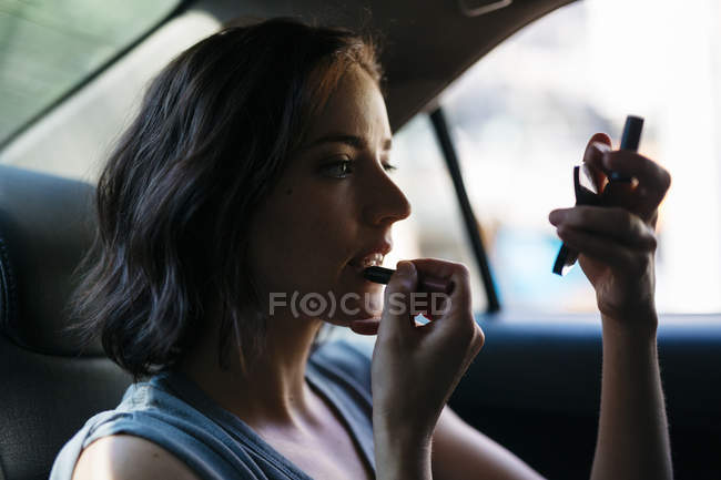 Porträt einer jungen Frau, die sich im Führerhaus schminkt — Stockfoto
