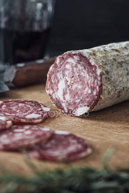 Sliced salami on wooden cutting board — Stock Photo
