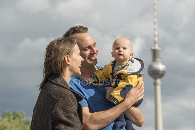 Coppia felice con bambino davanti alla torre della televisione — Foto stock