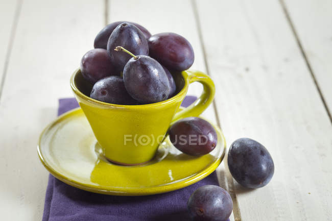 Prunes en tasse jaune — Photo de stock