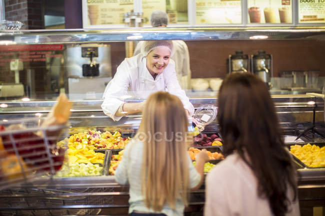 Mother and daughter buying fruit salad in supermarket — Stock Photo