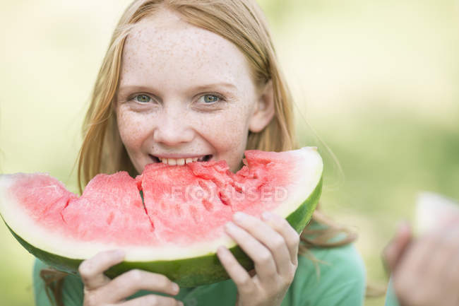 Retrato de menina com cabelo vermelho comendo fatia de melancia — Fotografia de Stock