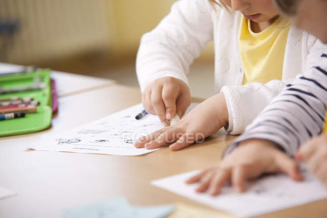 Close-up of Schoolgirls working on work sheets in classroom — Stock Photo