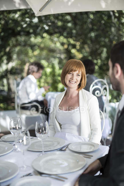 Жінка посміхається чоловікові в ресторані — стокове фото
