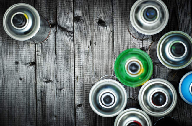 Aerosol cans on wooden surface — Stock Photo