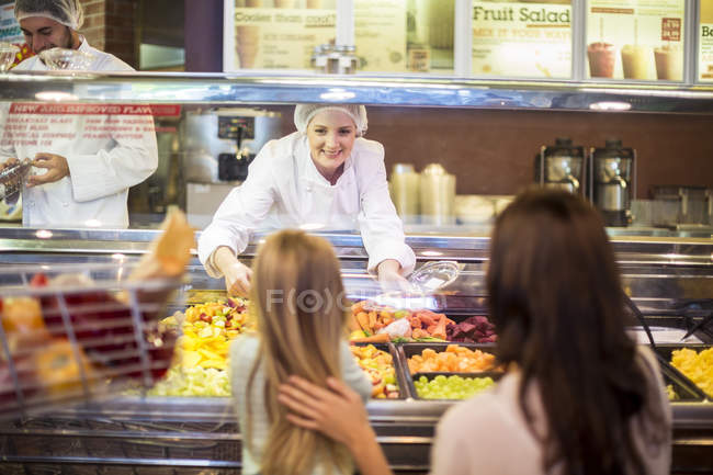 Mother and daughter buying fruit salad in supermarket — Stock Photo